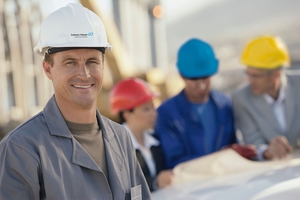 An Endress+Hauser engineer smiles at the camera, other engineers are behind him