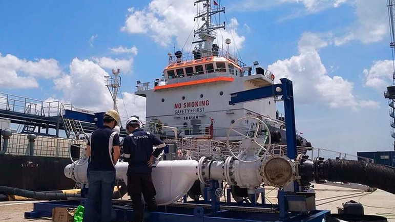 An Endress+Hauser master meter proving skid in front of a Singapore bunker tanker at the port