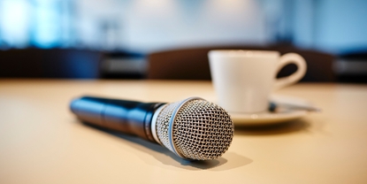 Press conference mood: microphone and coffe cup on a table.